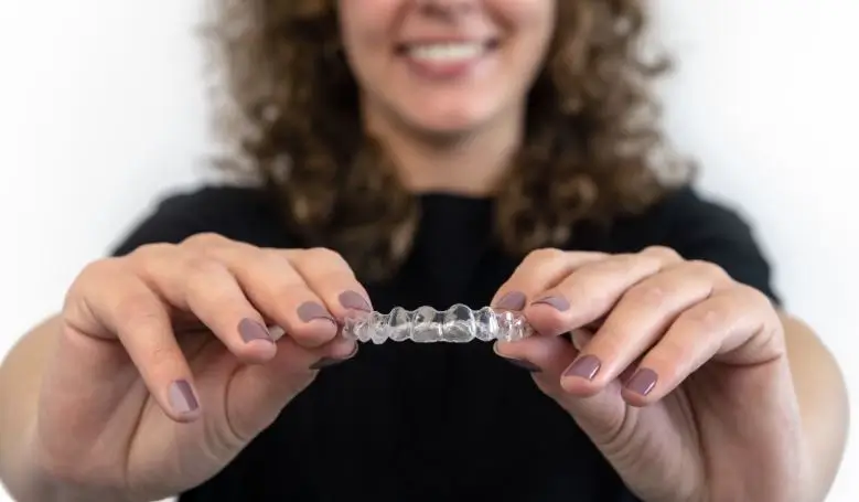 Woman holding a clear aligner.