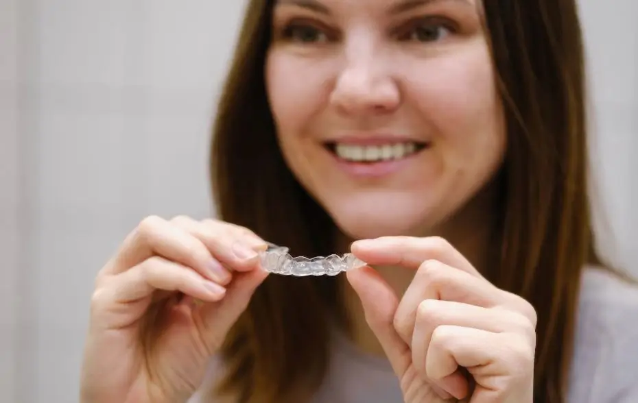 Woman holding a clear retainer.